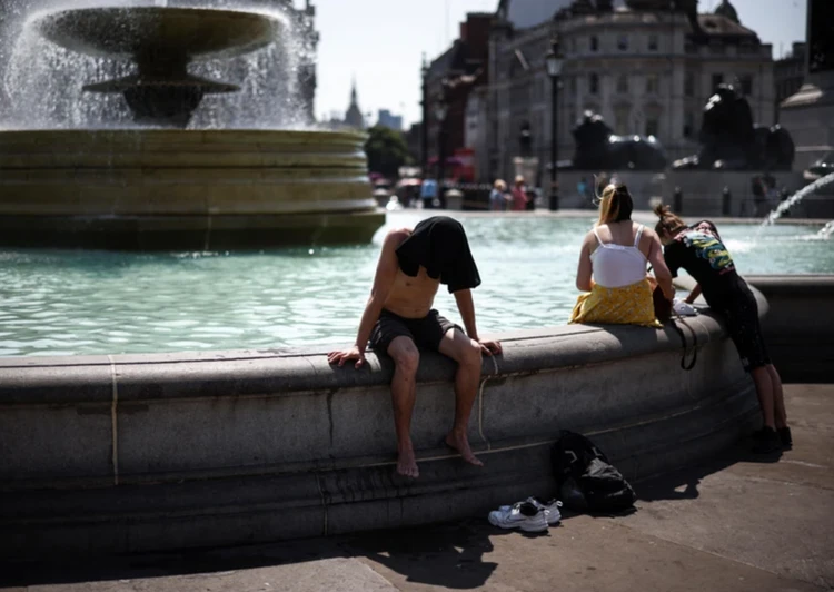 Người dân giải nhiệt cạnh đài phun nước Quảng trường Trafalgar trong đợt nắng nóng kỷ lục, London, Anh. (Ảnh: REUTERS)